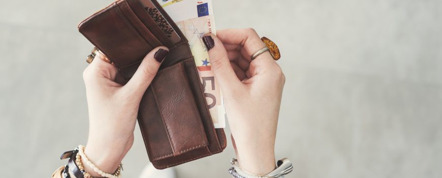 Woman taking out  euro money from her pocket wallet top view