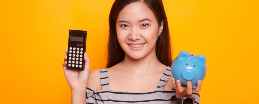 Asian woman with calculator and piggy bank.