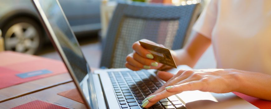 Girl with a laptop in a cafe, shop with a credit card