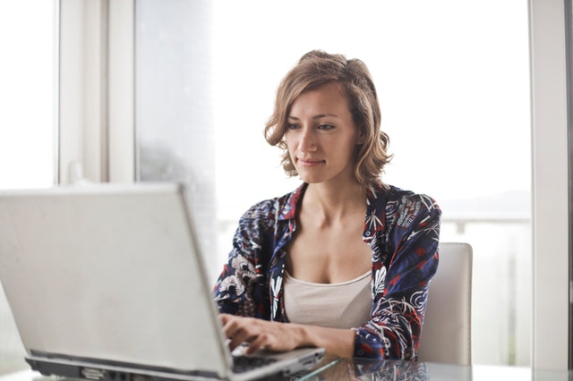 woman-in-blue-floral-top-sitting-while-using-laptop-806835